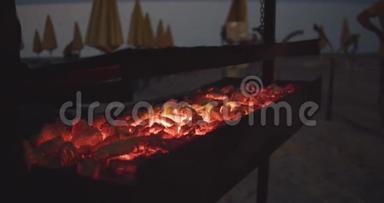海滩上烤架上的红色发光的煤。 海滩烧烤。 晚上好。 慢动作